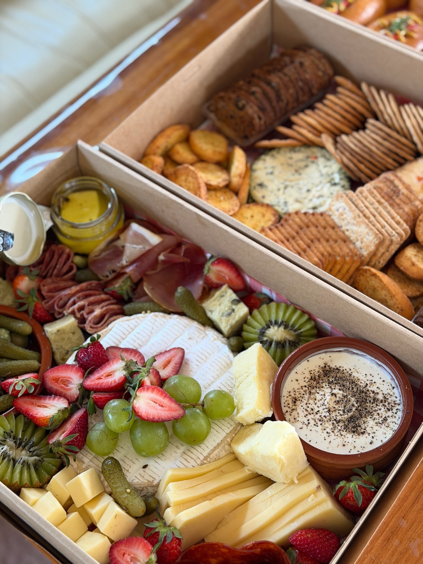 Charcuterie and cheese boxes with crackers and fruit