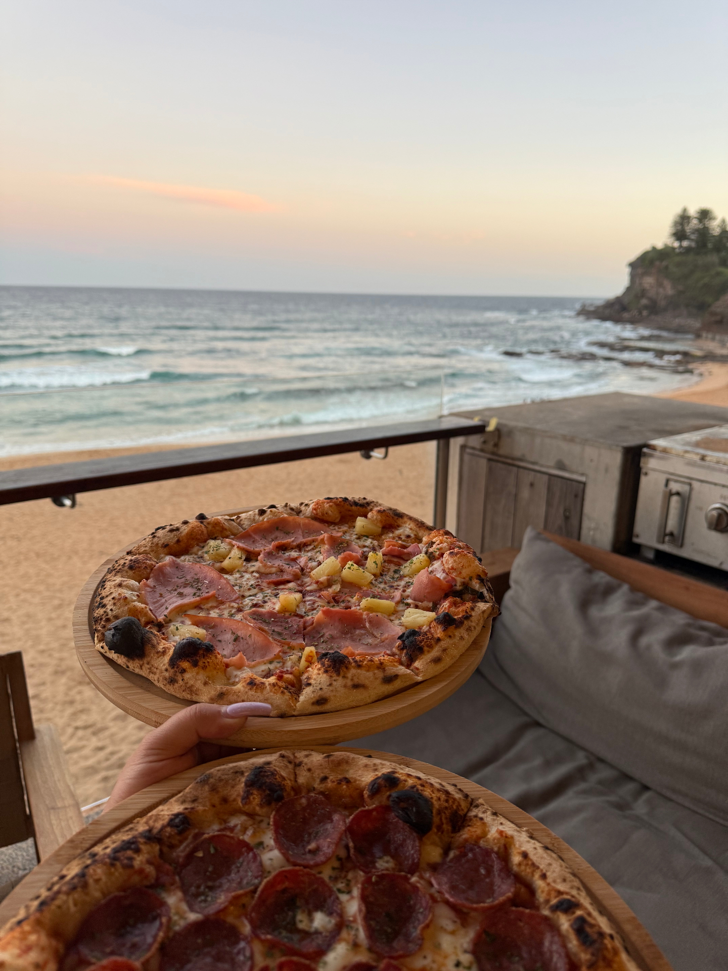 Two wood-fired pizzas served overlooking the beach at sunset