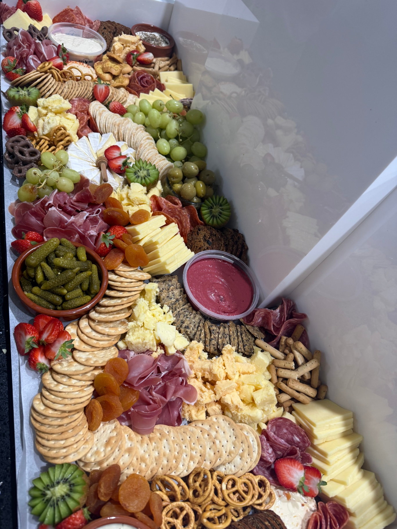 Grand grazing table loaded with cheeses, charcuterie and fruit