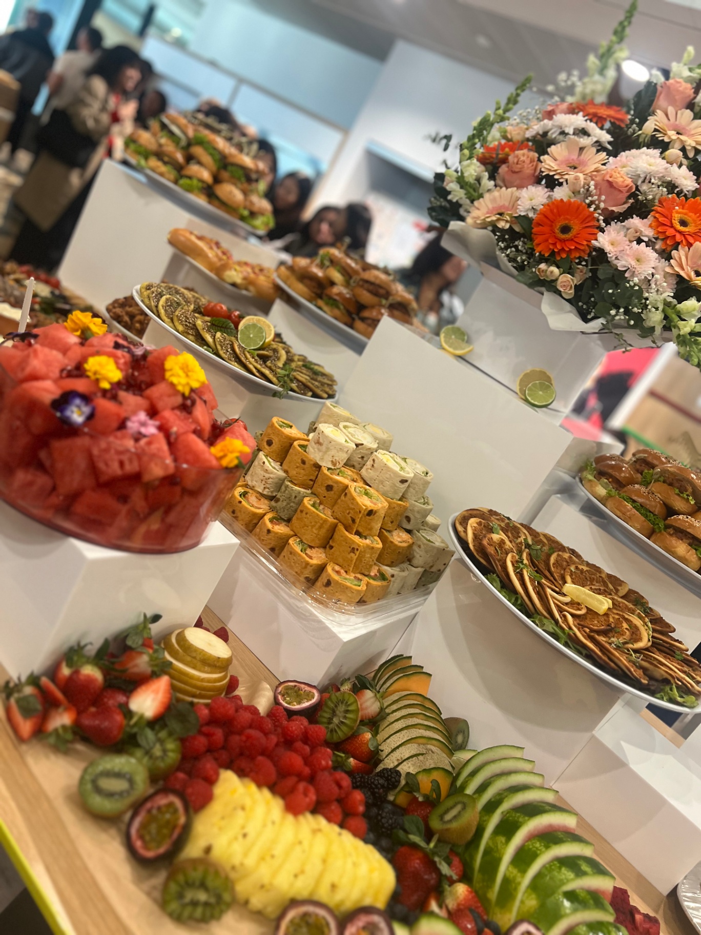 Tiered event buffet with fruit, wraps and sliders