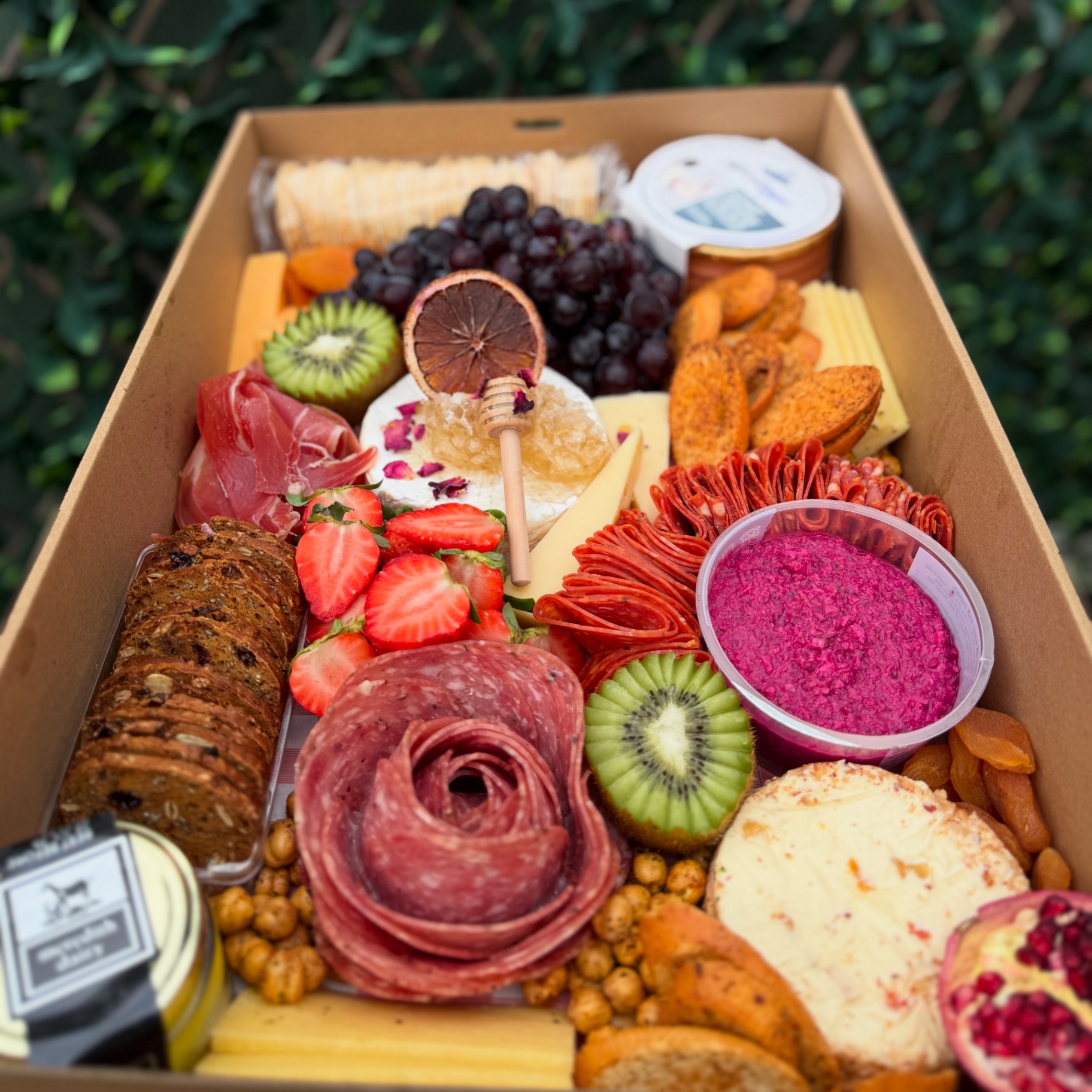 Box with salami rose, brie, strawberries and dips