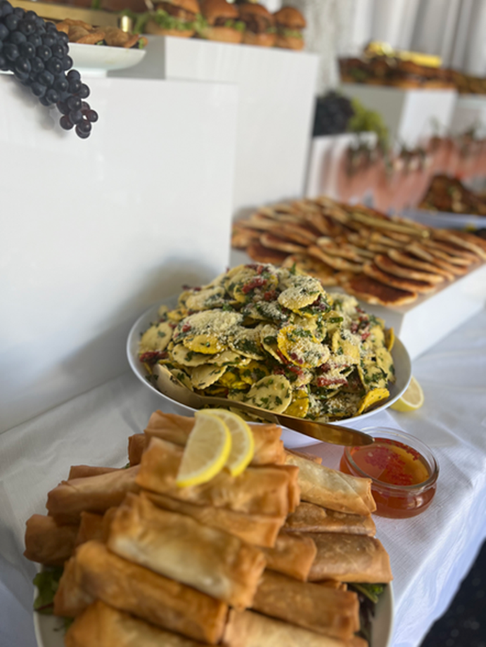 Spring rolls, pasta salad and flatbreads on a catering table