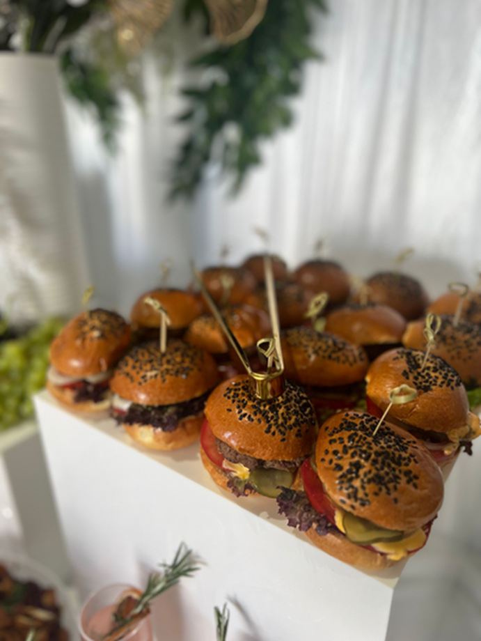 Mini slider burgers presented on white stands
