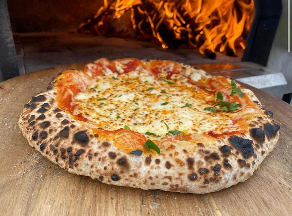 Wood-fired pizza in a flaming oven