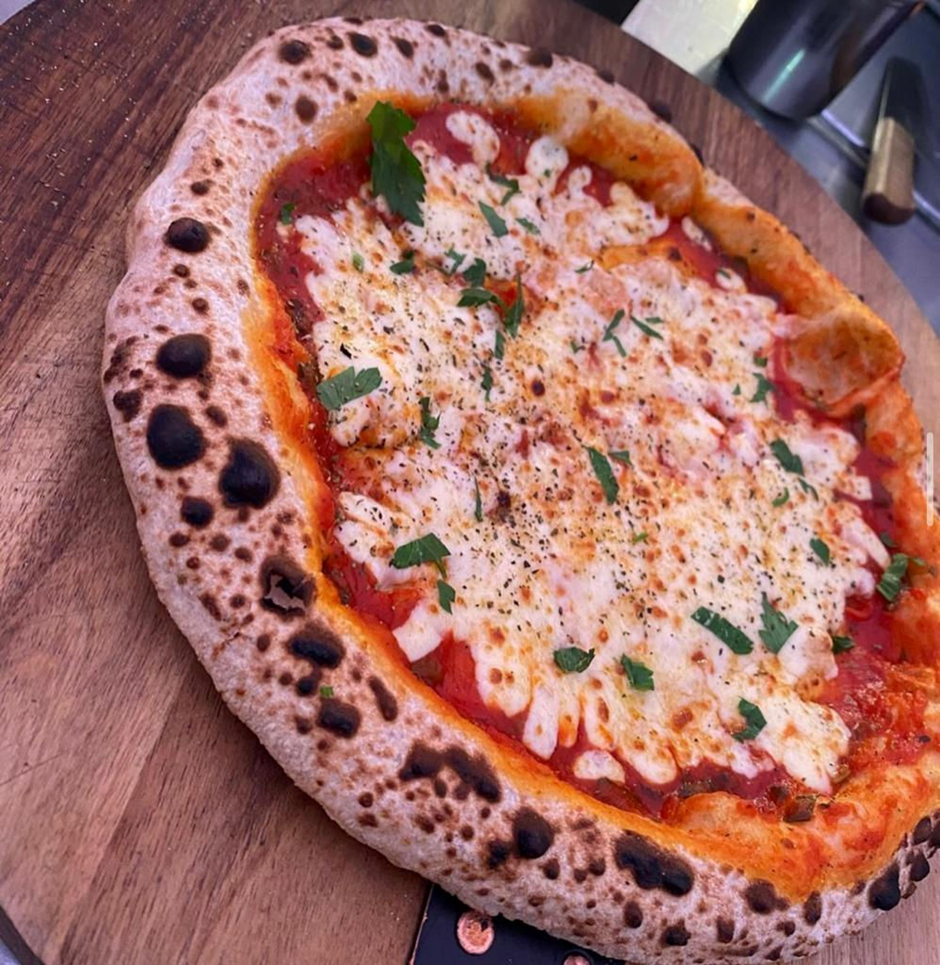 Wood-fired Margherita pizza on a timber board